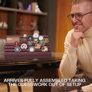 May include: A display stand with a burgundy finish, holding a collection of military challenge coins. The stand features an American flag design. The coins are round with various emblems and colors.