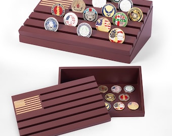 May include: A burgundy wooden display case with an American flag design, holding numerous collectible coins. The coins feature various emblems and designs, showcasing a range of colors and details. The case is open, revealing additional coins.