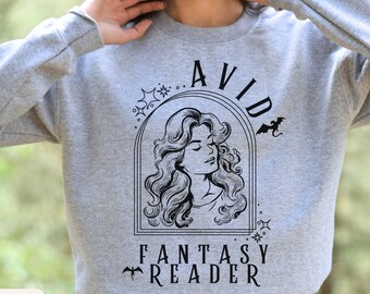 May include: A grey sweatshirt with a black graphic design featuring a woman with long hair and the text "Avid Fantasy Reader".