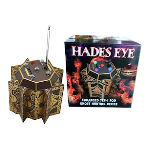 May include: A gold and brown, star-shaped device with a silver antenna and several lights, next to a box with the text "HADES EYE" and "ENHANCED TEP-1 POD GHOST HUNTING DEVICE".