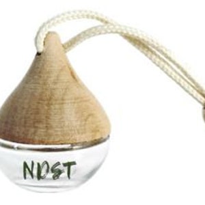 May include: A clear glass diffuser with a wooden top and a cream-coloured string for hanging. The word "NDST" is printed in green on the glass. The diffuser is designed to hold essential oils or fragrance.