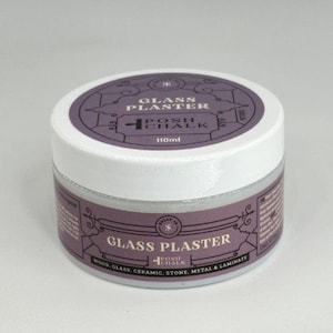 May include: A small, round jar of "Glass Plaster" by Posh Chalk. The jar has a white lid and a purple label with the product name and brand. The label also indicates the volume is 110ml. The product is for wood, glass, ceramic, stone, metal, and laminate.