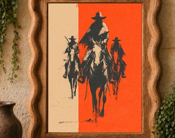 May include: A framed wall art print featuring a black ink illustration of three figures on horseback wearing wide-brimmed hats. The background is split vertically between a cream-colored section on the left and a vibrant orange section on the right.