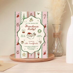May include: A festive Christmas party invitation with a pink and white striped background. The invitation features holiday-themed illustrations and text that reads "Friendsmas Party!" with the date and time. The invitation is on a wooden tray.