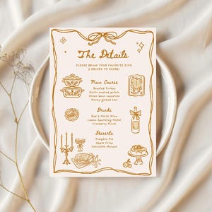 Puede incluir: Una tarjeta de men&uacute; beige con ilustraciones y texto dorados. El texto dice "The Details" y enumera un plato principal, bebidas y postres. El men&uacute; est&aacute; en un plato blanco, con un fondo de tela beige.