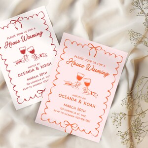 May include: Two pink and white housewarming party invitations with red and white illustrations of wine glasses and a bow. The text on the invitations reads "Please join us for a House Warming" and includes the names of the hosts, the date, and the address.