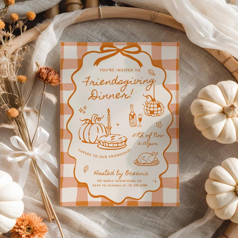 May include: A rectangular Friendsgiving dinner invitation card with a light orange and white gingham background. The center features a scalloped frame with orange line art of a pumpkin, pie, candle, champagne bottle, and disco ball.