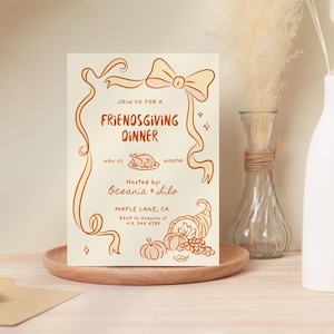 May include: A Friendsgiving dinner invitation card with a cream background and brown illustrations. The card features a bow, ribbons, a roasted turkey, pumpkins, and a cornucopia. The text reads "Join us for a Friendsgiving Dinner" and includes the date, time, and host information.