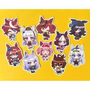 May include: Ten anime-style character stickers are displayed. Each sticker depicts a different female character with large eyes, colourful hair, and detailed outfits. The stickers are arranged on a yellow background.