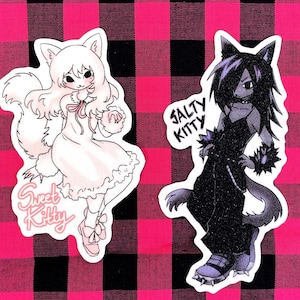 May include: Two cartoon cat stickers. One sticker is white with pink accents and says "Sweet Kitty". The other sticker is black with purple accents and says "Salty Kitty".