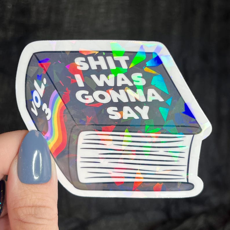 K&ouml;nnte beinhalten: Ein holografischer Aufkleber eines Buches mit dem Text "Vol. 33: Shit I Was Gonna Say" auf dem Cover.