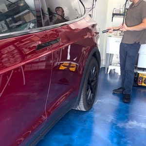 Here a Tesla X owner who talks about Tesla and Elon Musk all day pulls down the electric vehicle charger cable holder to charge his red Tesla X!