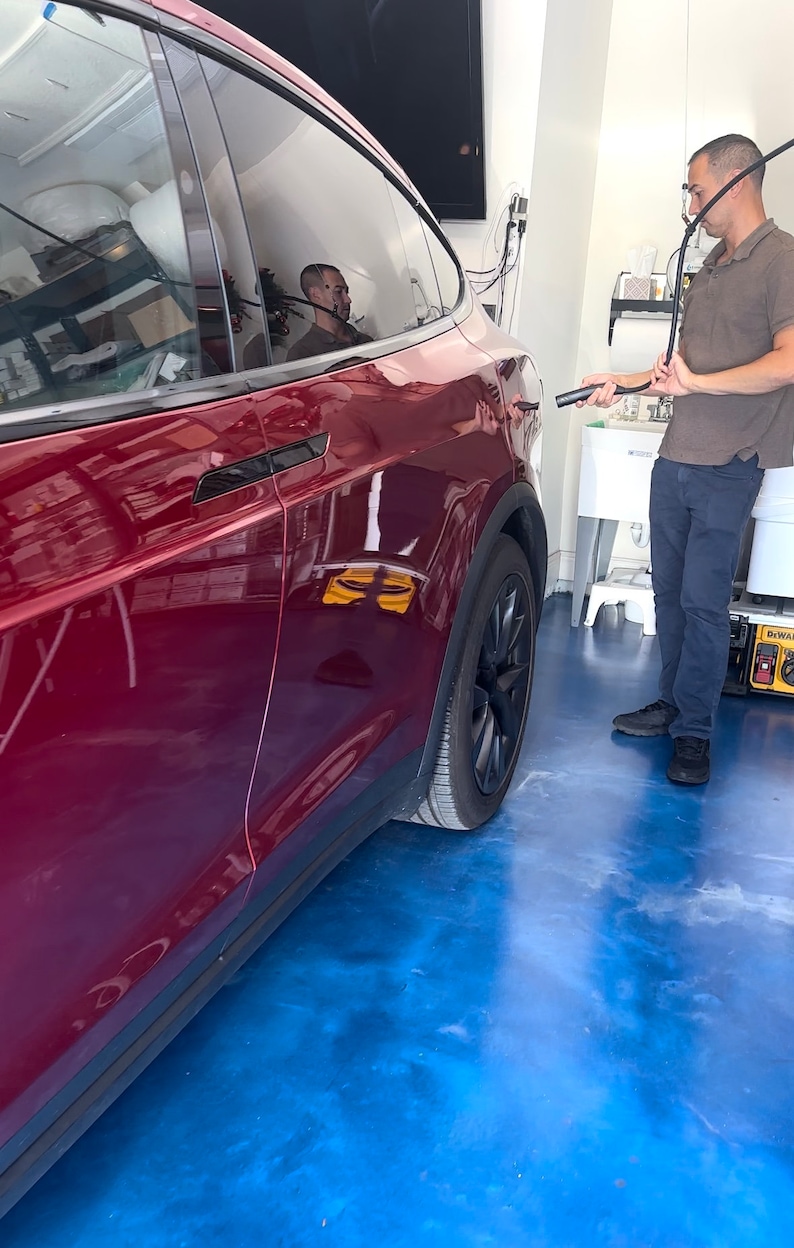 Here a Tesla X owner who talks about Tesla and Elon Musk all day pulls down the electric vehicle charger cable holder to charge his red Tesla X!