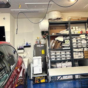 The Tesla charging cable hangs high on the ceiling and over the car.