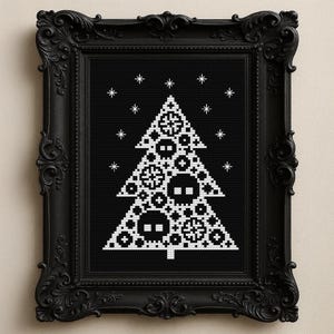 May include: A framed cross-stitch art piece featuring a white Christmas tree design on a black background. The tree is decorated with geometric shapes and snowflakes. The frame is black and ornate.