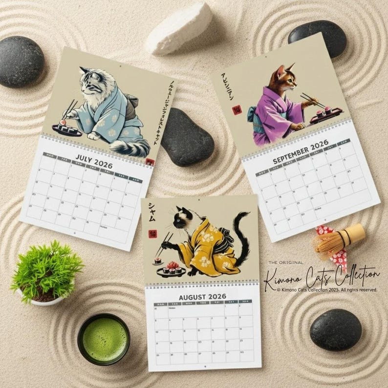 Three calendar pages for July, August, and September 2026 are arranged on a sand-raked surface, each featuring a cat in a kimono eating sushi.