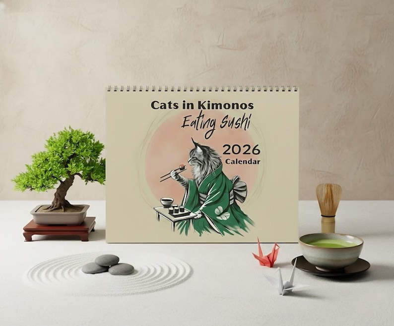 A spiral-bound wall calendar titled "Cats in Kimonos Eating Sushi 2026 Calendar" features an illustration of a cat in a green kimono eating sushi with chopsticks.