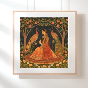 Op de afbeelding: Een vrouw in een rode en oranje jurk zit in een tuin met twee pauwen. De pauwen hebben groene en blauwe veren. De vrouw wordt omringd door groen gebladerte en bloemen.