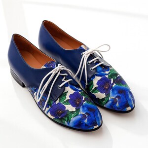 Handmade blue leather oxford shoes with vibrant floral print and white laces.