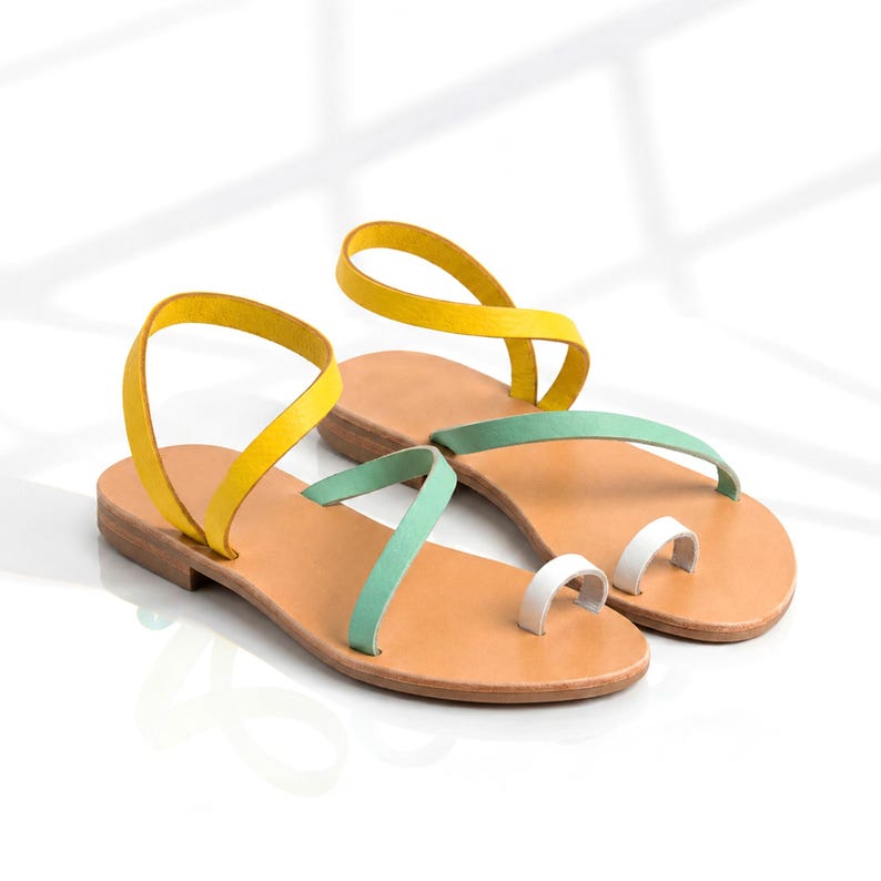 Vacation-ready Greek leather sandals with lightweight flat sole and fresh mint, yellow and white leather straps.