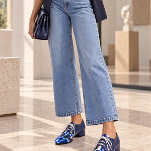 Women’s floral Oxford shoes with light denim and navy blazer editorial styling.