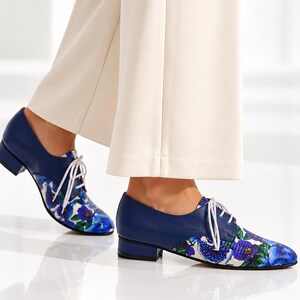 Side view of women’s blue floral Oxford shoes with low block heel.