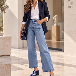 Blue floral Oxford shoes styled with jeans and navy blazer in a modern gallery.
