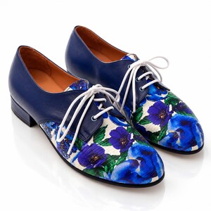 Pair of blue floral Oxford shoes photographed at a 45 degree angle.