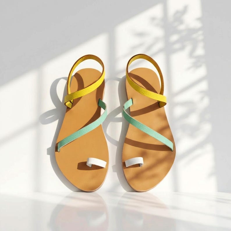 Close-up of handmade colorful sandals showing the leather texture, tan sole and slim summer strap construction.