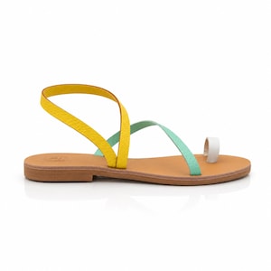 Flat Greek leather sandals in a colorful mint, yellow and white design, styled for summer vacation outfits.