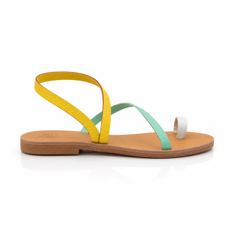 Flat Greek leather sandals in a colorful mint, yellow and white design, styled for summer vacation outfits.