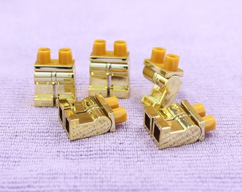 May include: Five gold-colored plastic Lego minifigure legs. The legs are all in different positions.