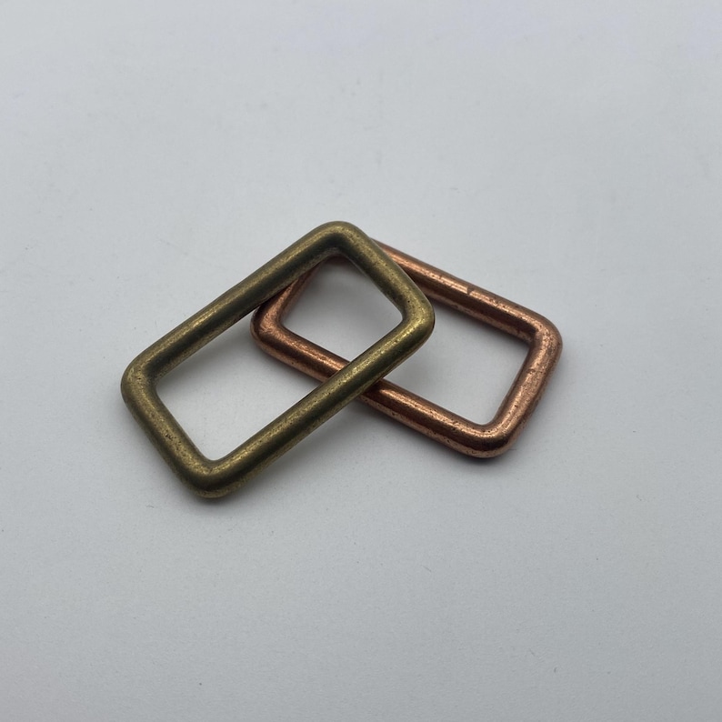 Peut inclure: Deux anneaux m&eacute;talliques, l'un en laiton et l'autre en cuivre. Les anneaux sont de forme rectangulaire et se chevauchent.