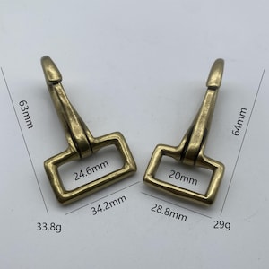 Puede incluir: Dos ganchos de cierre giratorios de latón con un bucle rectangular. El gancho más grande mide 6,3 cm de largo y 3,3 cm de ancho. El gancho más pequeño mide 6,3 cm de largo y 2,5 cm de ancho.