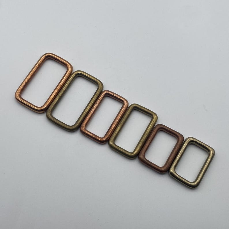 Peut inclure: Un ensemble de six anneaux m&eacute;talliques rectangulaires de diff&eacute;rentes tailles et nuances de cuivre, bronze et laiton.