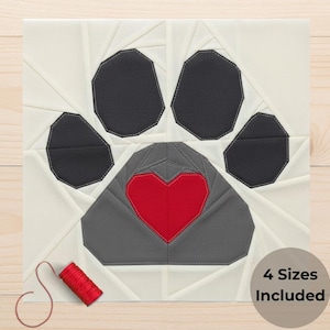 May include: A fabric block featuring a dog paw design with a red heart in the center. The paw pads are black, and the heart is red. The background is white with geometric stitching. A spool of red thread is in the lower left corner. Text reads "4 Sizes Included".