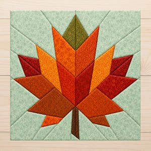 May include: A square quilt block featuring a central maple leaf design constructed from various fabric pieces in shades of red, orange, yellow, and brown. The leaf is set against a light green background with a subtle floral pattern.