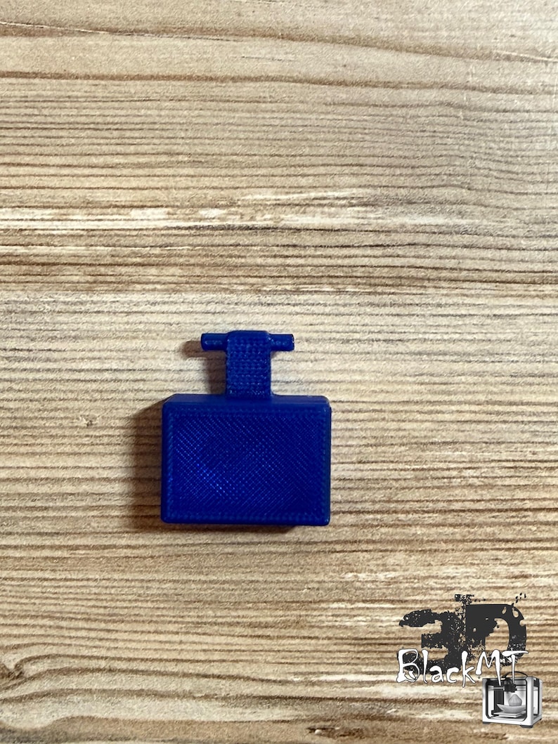 Op de afbeelding: Een kleine, rechthoekige component van koningsblauw plastic met een plat, getextureerd oppervlak en een verticaal lipje dat uit het midden van de bovenkant steekt. Het object heeft een 3D-geprinte afwerking met zichtbare kruispatronen.