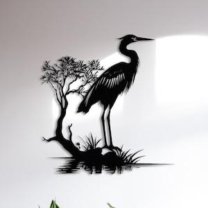 May include: Black metal wall art featuring a heron standing on a branch with water reflection. The heron is in silhouette against a white background.