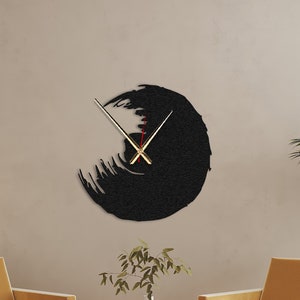 Może przedstawiać: Czarny abstrakcyjny zegar ścienny ze złotymi wskazówkami na białym tle. Na pierwszym planie znajdują się dwa musztardowo-żółte fotele i mały stolik z rośliną w doniczce.