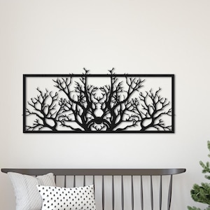 May include: Black metal wall art featuring a stylized tree branch design. The art is rectangular and hangs on a white wall above a wooden bench.