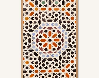 May include: A framed print of a geometric pattern in shades of orange, blue, black, and white. The pattern is made up of repeating shapes and lines, creating a complex and intricate design.