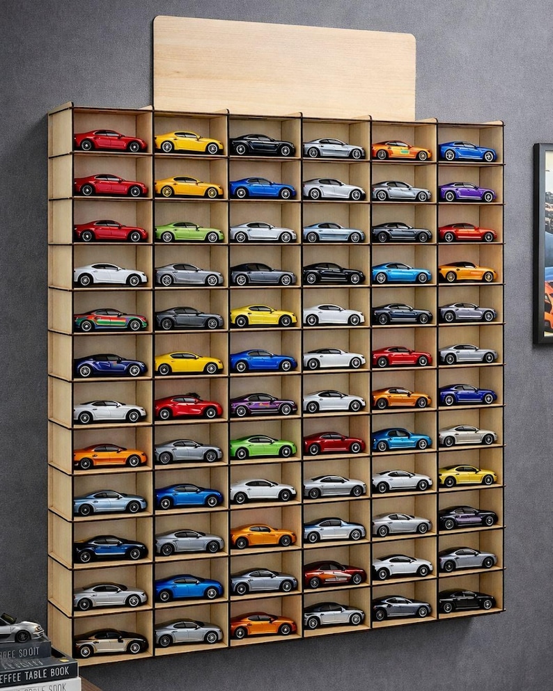 May include: A wall-mounted wooden display shelf with six vertical columns and ten horizontal rows, featuring individual compartments for toy cars. The unit is filled with various miniature model cars in diverse colors including red, yellow, blue, and silver.