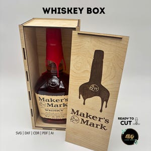 May include: A wooden whiskey box with the text "WHISKEY BOX" at the top. Inside is a bottle of Maker's Mark whiskey with a red wax seal. The box's front panel features a laser-cut design of the Maker's Mark bottle shape and logo.