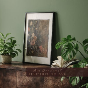 May include: A framed painting of a floral still life with a dark background and a variety of flowers in shades of pink, red, and white. The painting is hanging on a green wall above a wooden shelf with a book and two potted plants.