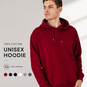 May include: A burgundy unisex hoodie made of 100% cotton. The hoodie has a front pocket and a drawstring hood. The text "100% Cotton Unisex Hoodie" is displayed on the left side of the image. Several color options are shown below the text.