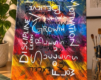 May include: A rectangular canvas painting featuring a vibrant, multi-coloured abstract background with blended streaks of blue, purple, red, and yellow. White text is layered over the surface, including words like Inspiration, Motivation, Discipline, Growth, Believe, and Success.