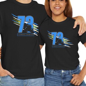 May include: Two black t-shirts with a blue and white graphic design featuring the number 79 and the text "2x World Champion".