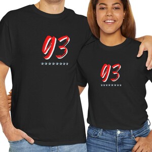 May include: Two black t-shirts with a red and white number "93" printed on the front. The number is stylized with a brushstroke effect and is surrounded by a row of small white stars.