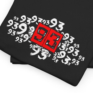May include: Black t-shirt with a red and white graphic design. The graphic features a red square with the number "93" inside, surrounded by white stylized numbers "93".
